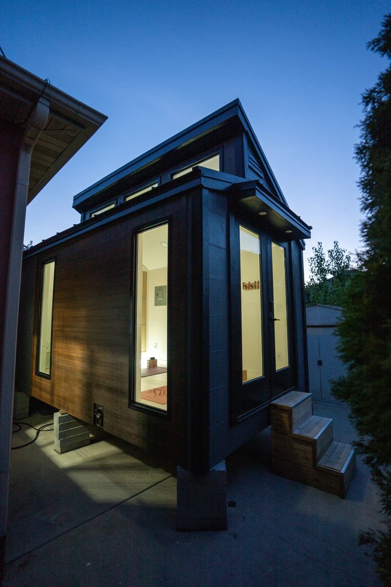 Sauna Haus side angle at dusk showing wood cladding and glass windows