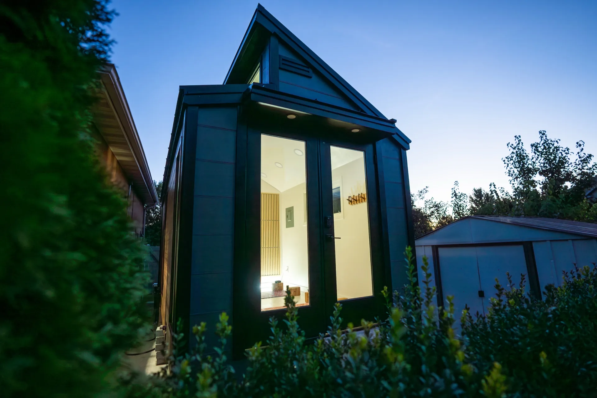 Sauna Haus exterior at twilight with warm interior glow